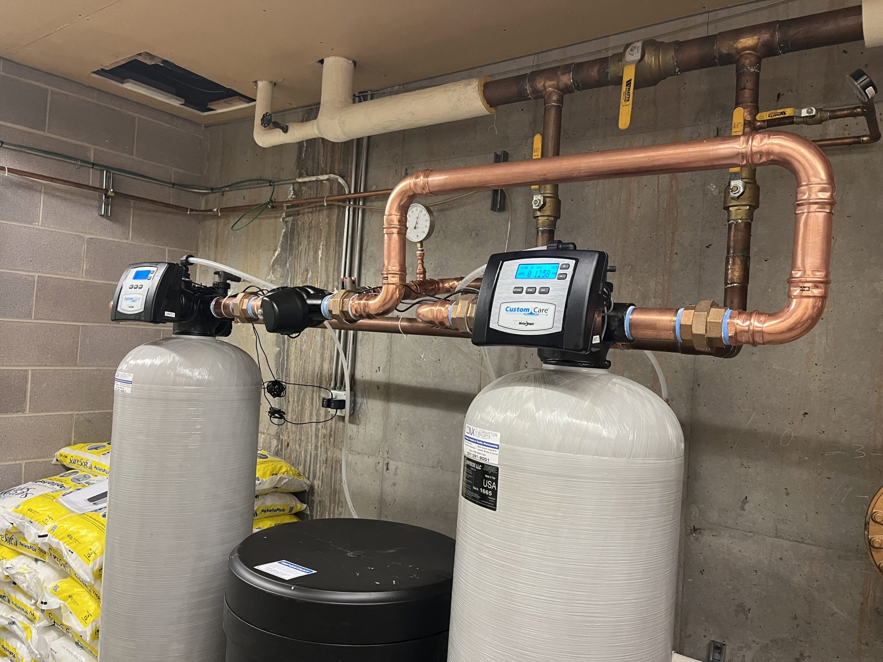 Two water softeners are connected to a pipe.